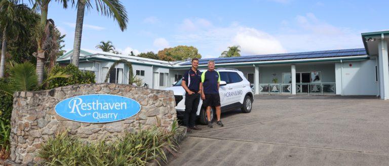 two men standing in front of a car in the driveway of Resthaven Aged Care