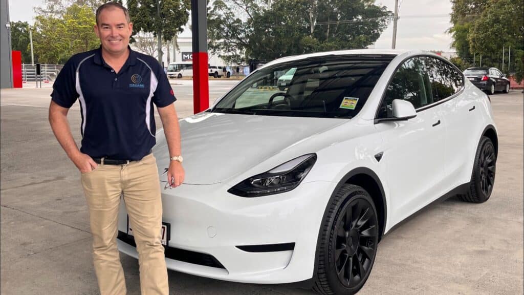 John Horan in front of a white Tesla during the EV Highway road trip