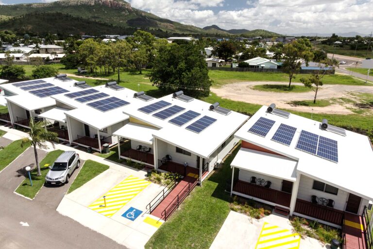 Solar panels installed on caravan park cabin roofs.